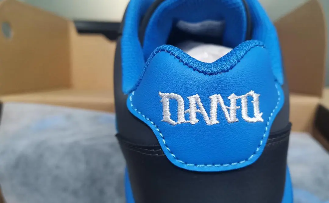 Close-up of a shoe heel with "DANFU" embroidered in white on blue fabric.