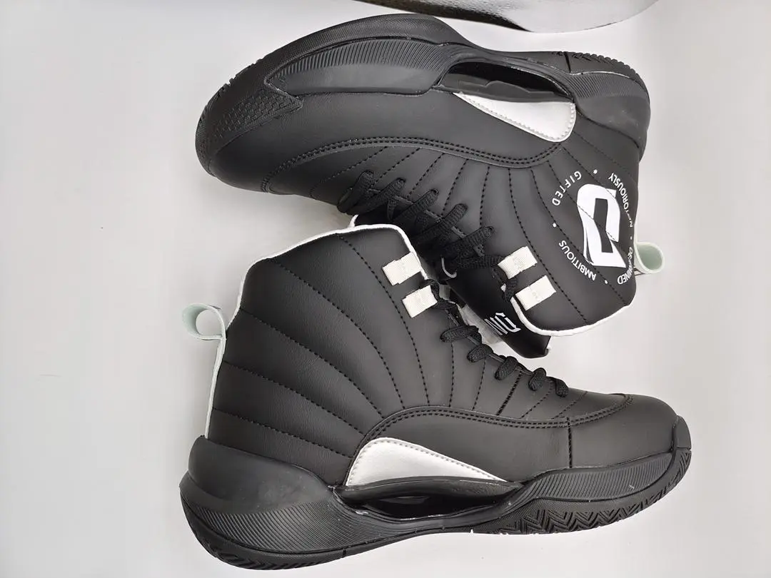 Black high-top athletic shoes with white accents on a white background.